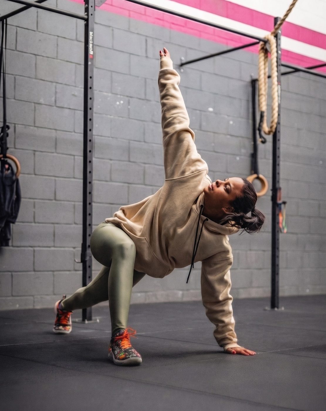 Atleta em alongamento ao lado de rack profissional Blackwolf